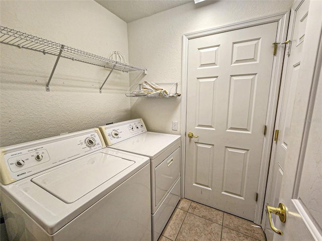 laundry room with light tile patterned floors and washing machine and clothes dryer