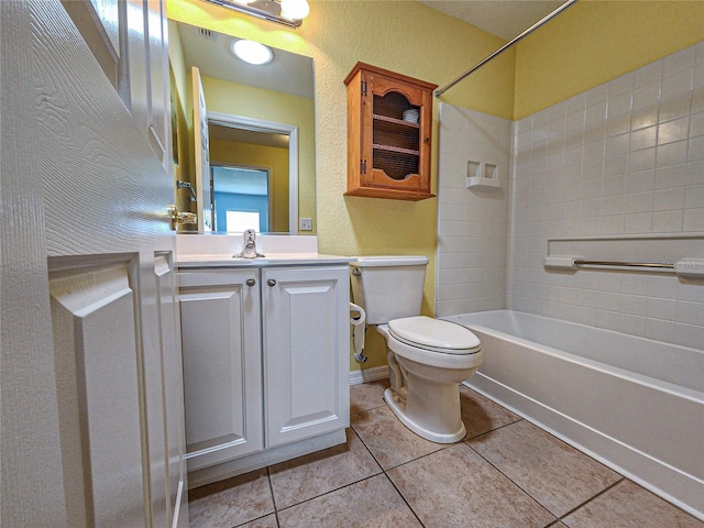 full bathroom featuring tiled shower / bath combo, tile patterned flooring, vanity, and toilet