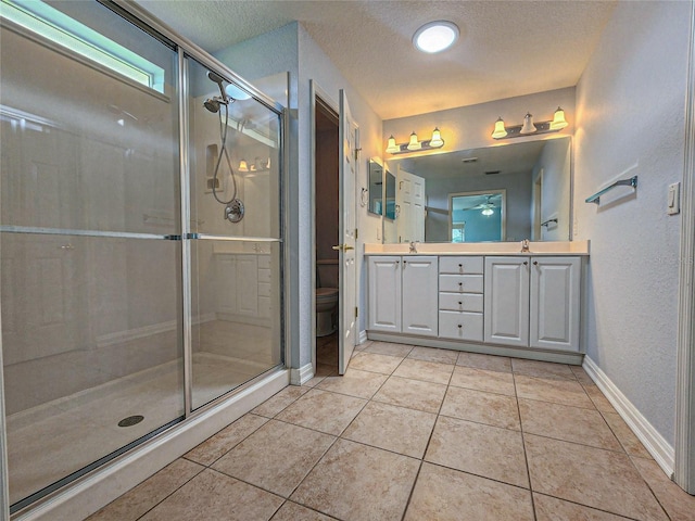 bathroom with vanity, tile patterned flooring, toilet, and a shower with door