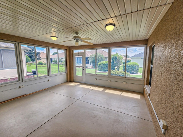 unfurnished sunroom with ceiling fan