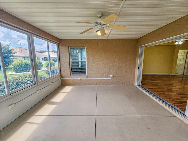 unfurnished sunroom featuring ceiling fan