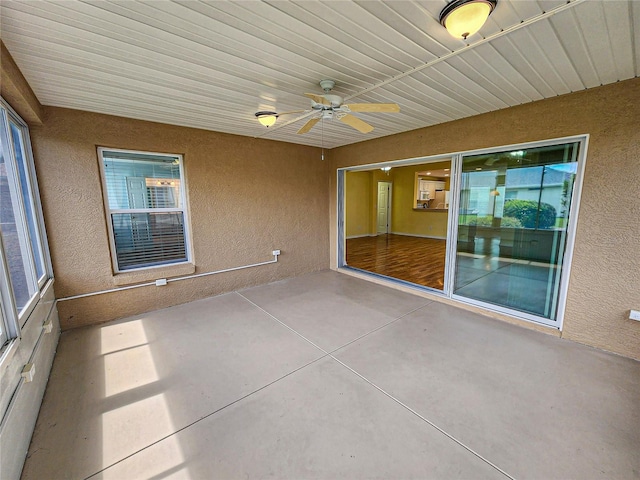 unfurnished sunroom with ceiling fan and a wealth of natural light