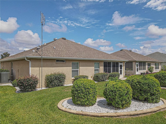 rear view of house featuring cooling unit and a yard