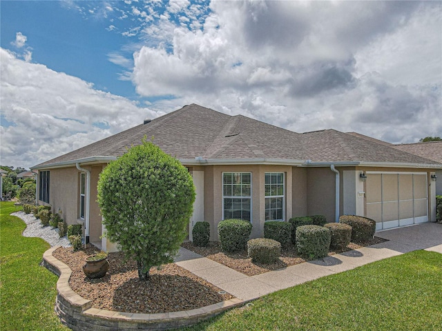 ranch-style home with a garage and a front lawn