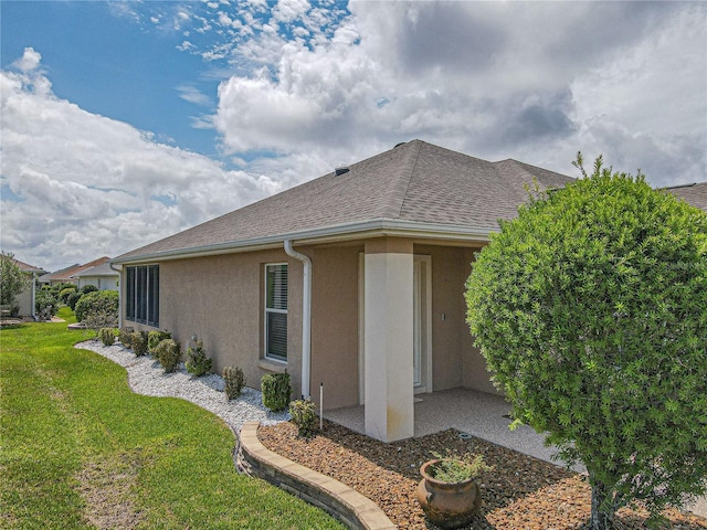 view of side of property with a lawn and a patio