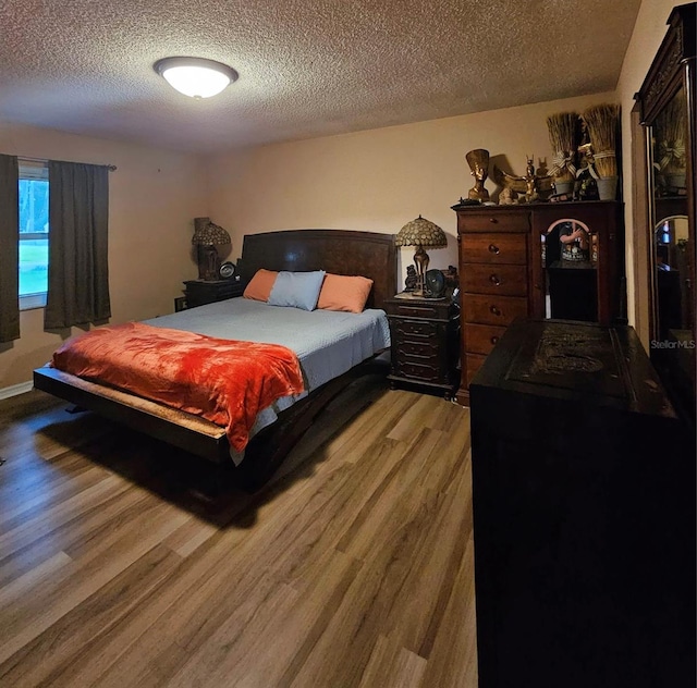 bedroom with a textured ceiling and hardwood / wood-style flooring