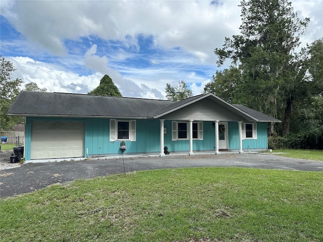 ranch-style house featuring aphalt driveway, an attached garage, a porch, and a front lawn