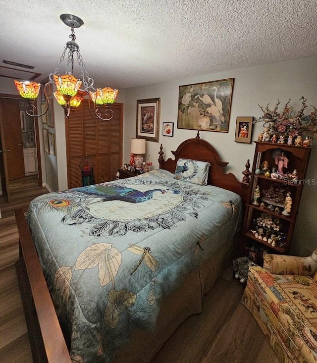 bedroom with a textured ceiling and dark wood-type flooring