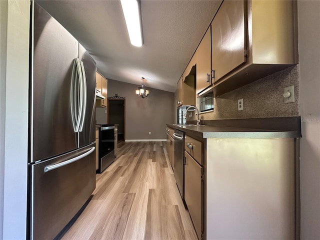 kitchen featuring a sink, decorative backsplash, vaulted ceiling, stainless steel appliances, and light wood-style floors