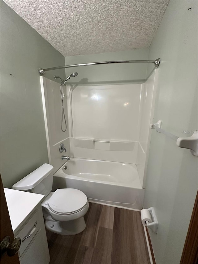 full bathroom featuring vanity, wood finished floors, a textured ceiling, shower / tub combination, and toilet