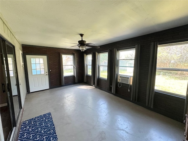 unfurnished sunroom with cooling unit and ceiling fan