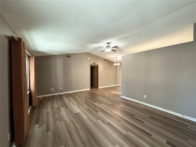 interior space with visible vents, baseboards, vaulted ceiling, ceiling fan with notable chandelier, and wood finished floors