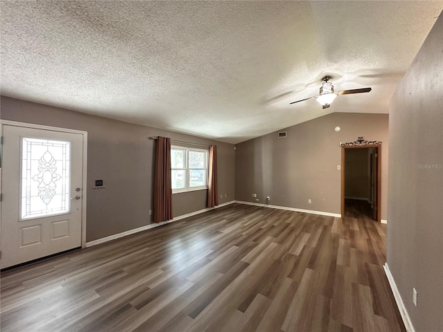 unfurnished living room with vaulted ceiling, wood finished floors, visible vents, and baseboards