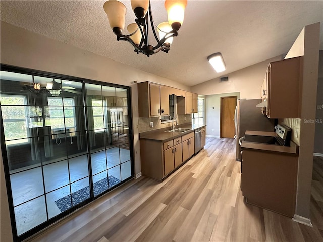 kitchen with visible vents, stove, vaulted ceiling, stainless steel dishwasher, and dark countertops