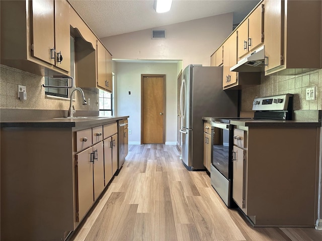 kitchen with visible vents, under cabinet range hood, lofted ceiling, appliances with stainless steel finishes, and a sink