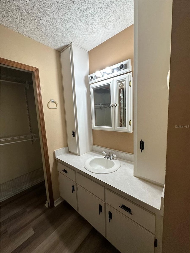 bathroom featuring a textured ceiling, vanity, and wood finished floors