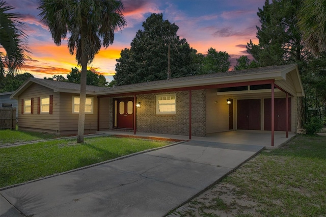 single story home featuring a lawn and a carport