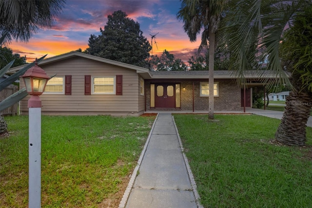 ranch-style home with a lawn