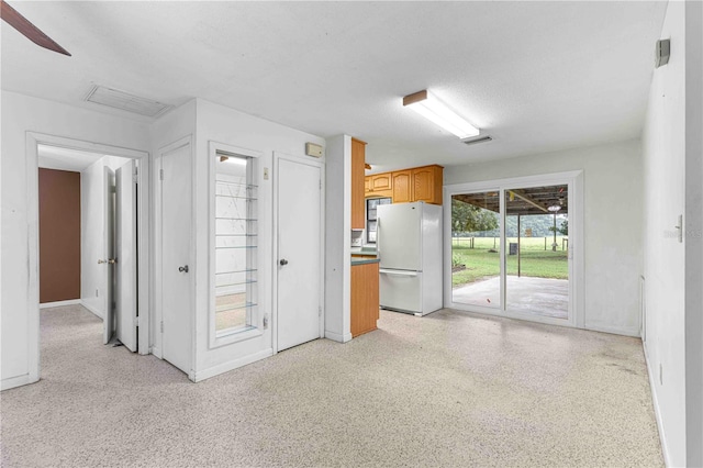 kitchen with white refrigerator and a textured ceiling