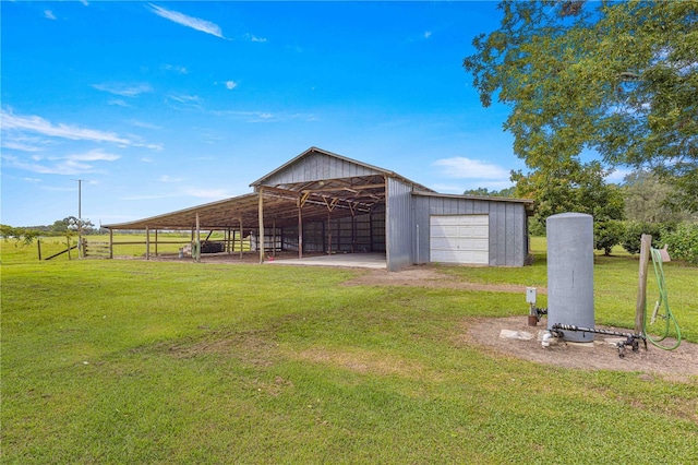 view of yard featuring a garage, an outdoor structure, and a rural view