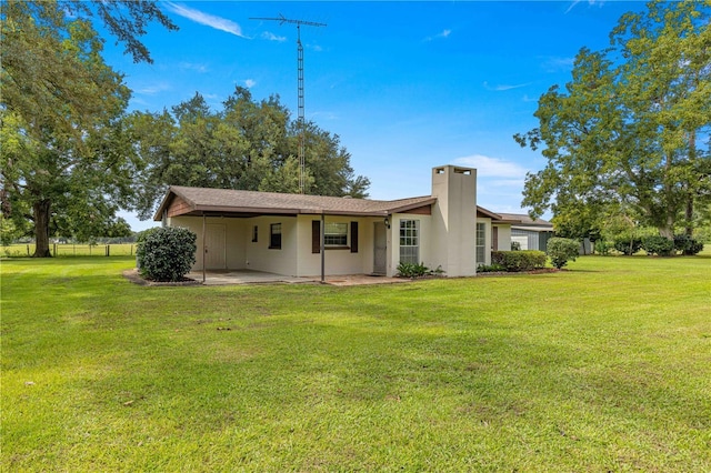 back of property featuring a lawn and a patio