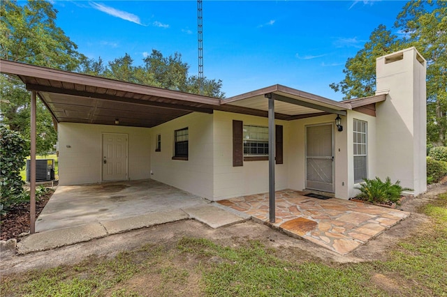 view of front of house with a carport and cooling unit