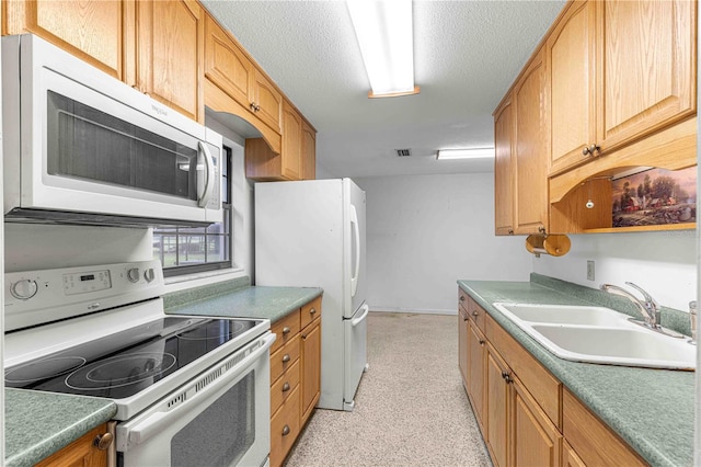 kitchen featuring sink, white appliances, and a textured ceiling