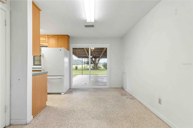 kitchen featuring a textured ceiling and white refrigerator