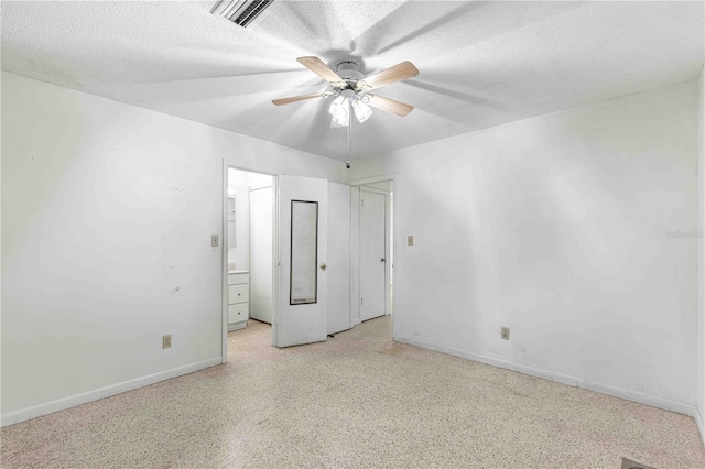 empty room featuring ceiling fan and a textured ceiling