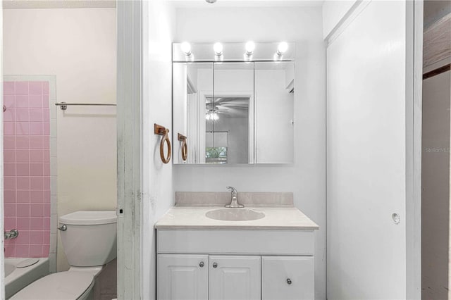 full bathroom featuring vanity, tiled shower / bath, ceiling fan, and toilet