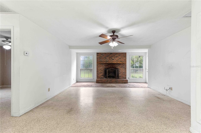 unfurnished living room with ceiling fan and a fireplace