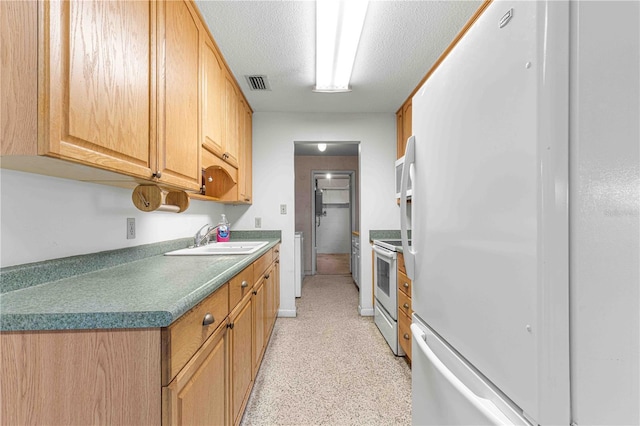 kitchen with sink, white appliances, and a textured ceiling