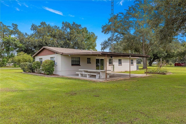 back of property with a yard and a patio