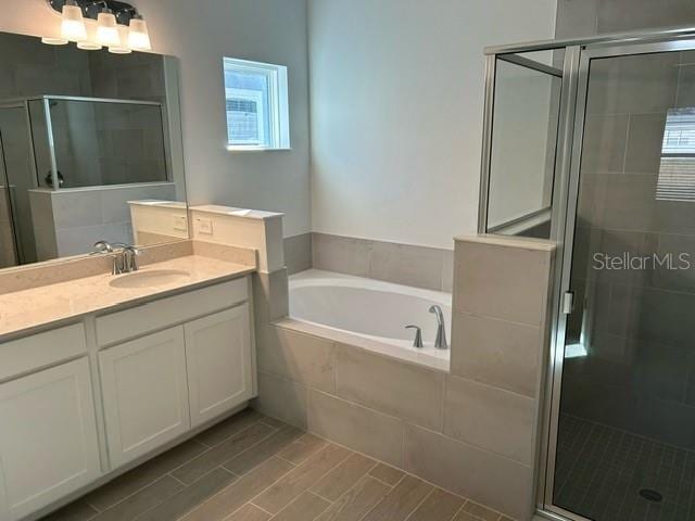 bathroom featuring vanity and shower with separate bathtub