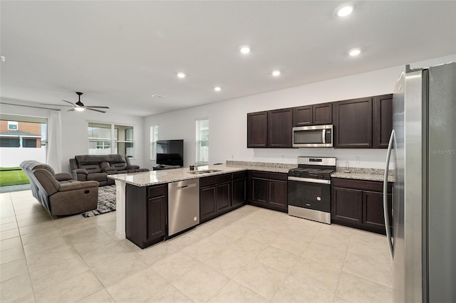 kitchen with ceiling fan, stainless steel appliances, kitchen peninsula, and a wealth of natural light