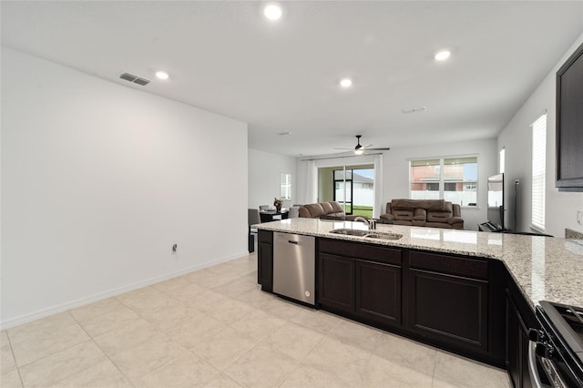 kitchen featuring light stone countertops, stainless steel appliances, ceiling fan, and sink