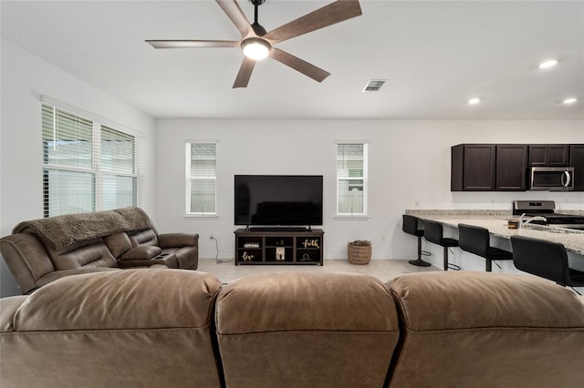 carpeted living room with ceiling fan