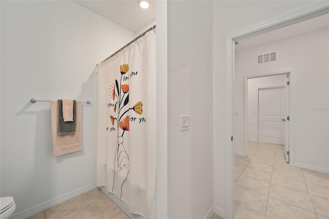 bathroom featuring tile patterned flooring, curtained shower, and toilet