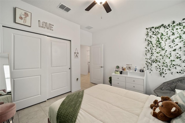 bedroom with a closet, light tile patterned flooring, and ceiling fan