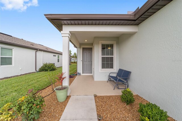 view of exterior entry with a lawn