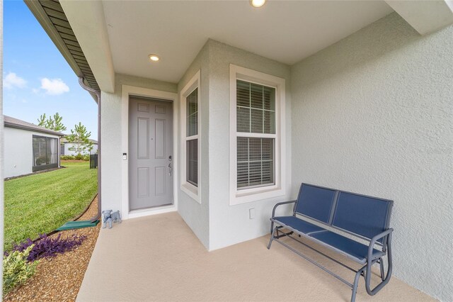 property entrance featuring a lawn