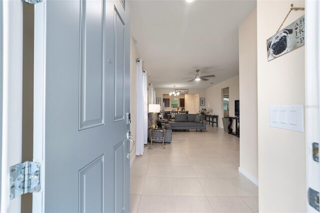 hallway featuring a chandelier and light tile patterned floors