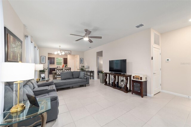 living room with ceiling fan with notable chandelier and light tile patterned floors