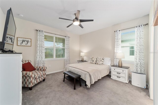 carpeted bedroom with multiple windows and ceiling fan