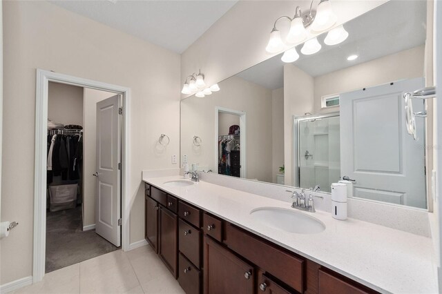 bathroom featuring a notable chandelier, vanity, tile patterned flooring, and an enclosed shower