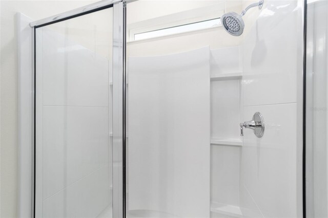 bathroom with a shower with door