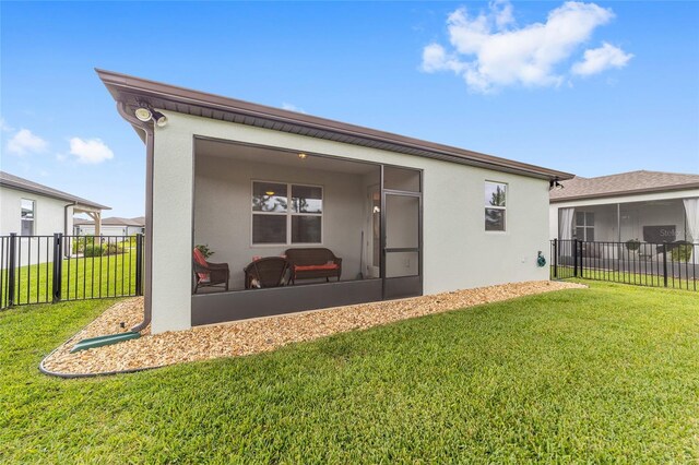 back of property featuring a sunroom and a yard