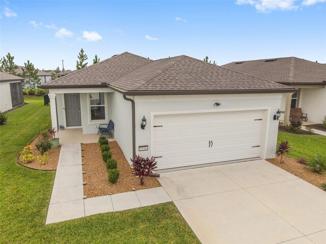 single story home with a garage and a front lawn