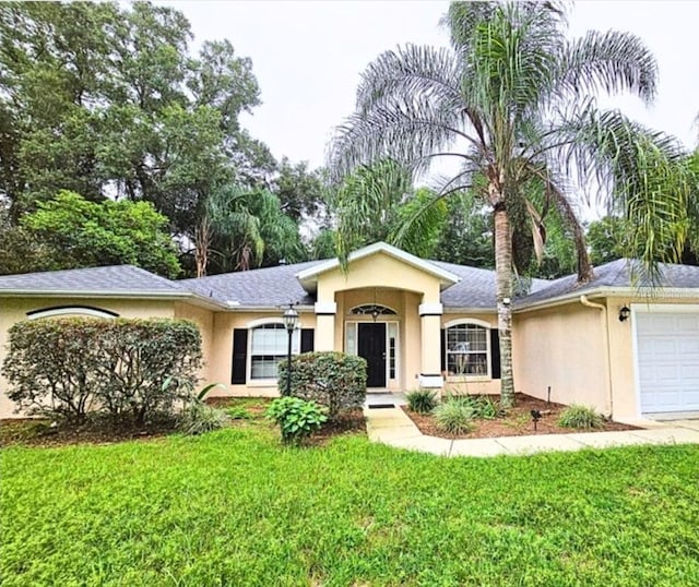 ranch-style house featuring a front yard and a garage