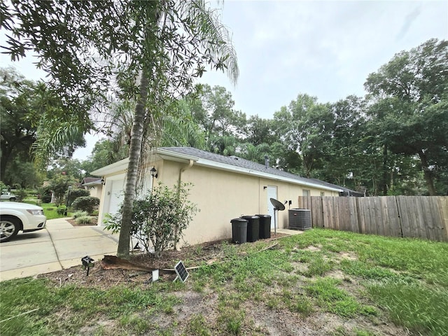 view of property exterior featuring central AC and a garage